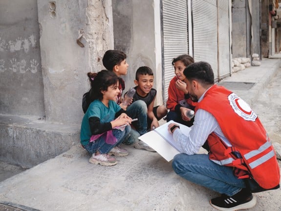 Barn och volontär från Röda Korset i Syrien
